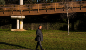 Old bridge behind a man walking along a path